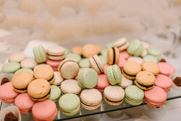 Macaroons, almond cookies. Candy bar closeup. Delicious wedding reception luxury ceremony. Table with sweets, candies, and dessert. Culinary and cooking concepts. Tasty colorful macaroons.`
