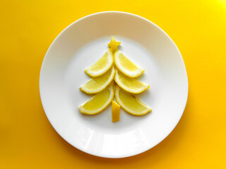 Healthy and cheerful food for children, Christmas and New Year, a lemon tree, on a white plate and a yellow background