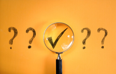 Magnifier enlarging the correct choice or check mark on yellow background. Business...