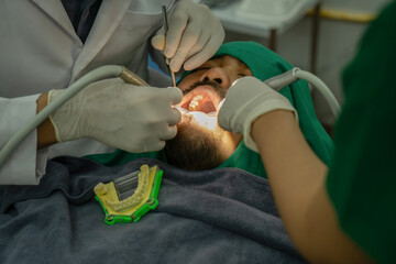 Image of man sitting in dental chair while professional doctor fixing teeth, Professional dental...