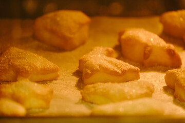 Process of baking cookies from puff pastry in the oven. Cooking cookies in the shape of a heart, an...