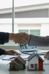 Business success, real estate agents and customers join hands to congratulate after signing the contract to buy a house with land and insurance. Remote Picture Vertical view