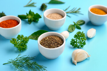 Composition with bowls of fresh aromatic spices and herbs on color background