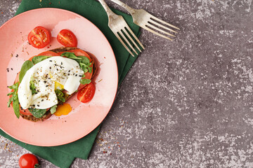 Plate of tasty sandwich with egg on grey background