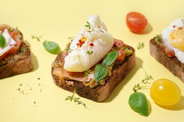 Tasty sandwiches with egg on yellow background