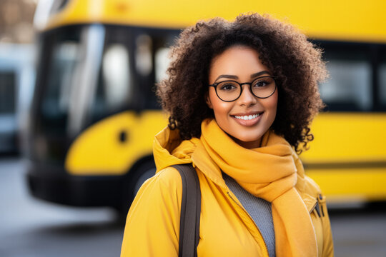 Confident driver woman standing against school bus 