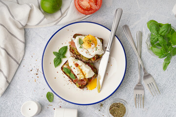 Plate of tasty sandwiches with egg on grey background