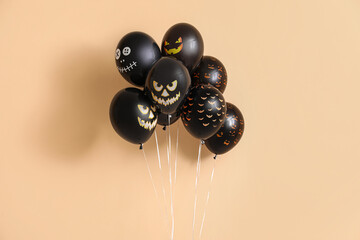 Different black Halloween balloons on beige background