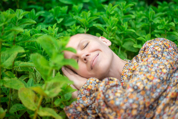 Woman sleeping in green mint leaves. Healthy sleep, aromatherapy concept. Adjusting the circadian...