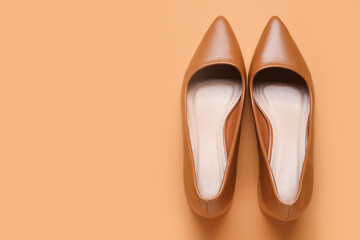 Stylish brown high heels on color background