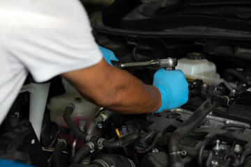 Fototapeta na wymiar closeup mechanic hands checking and fixing a car in garage