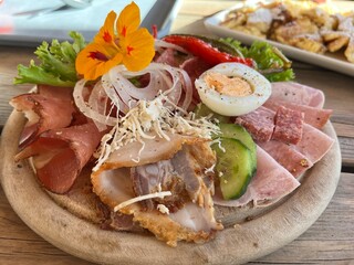 Delicious platter of cold cuts, egg and vegetables, decorated with a flower