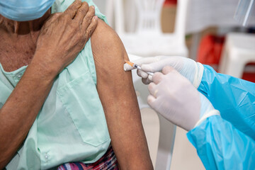 Immunization and vaccination for flu shot, influenza , HPV or Covid-19 prevention with old woman in the hospital having vaccine injection for World immunization week and International HPV