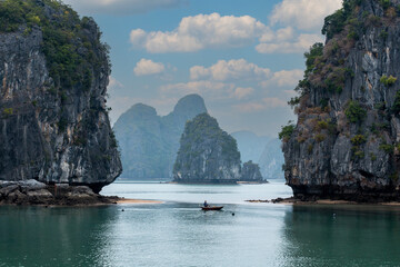 Traditional boats between picturesque limestone cliff islands in Ha Long Bay in northern Vietnam