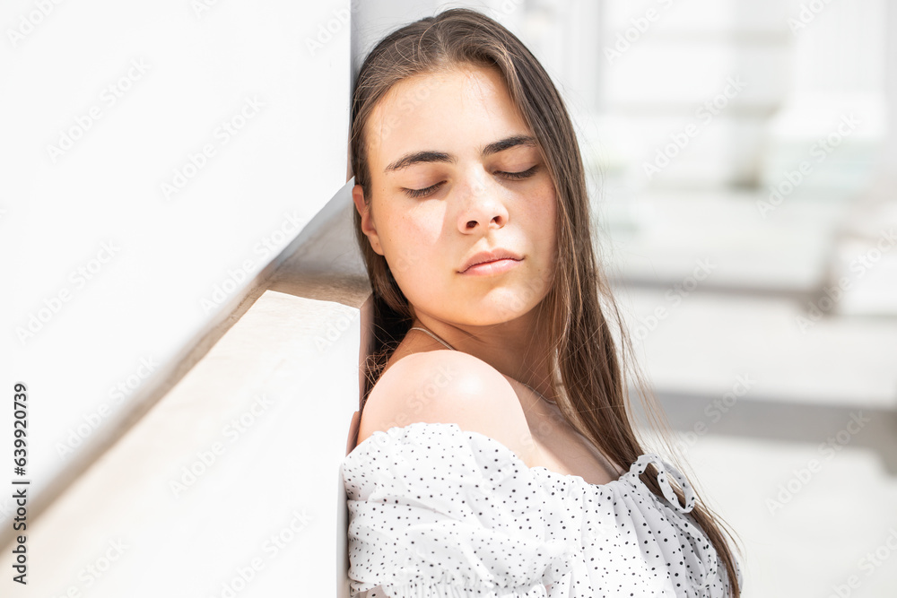 Wall mural Portrait of a young beautiful brunette woman in a white dress