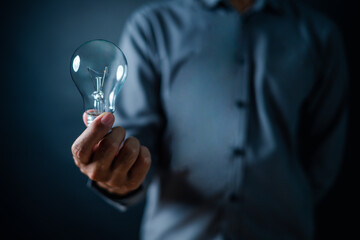 lamp, light bulb, close up, hand, businessman, portrait, background, blue, hold, ideas. picture is...