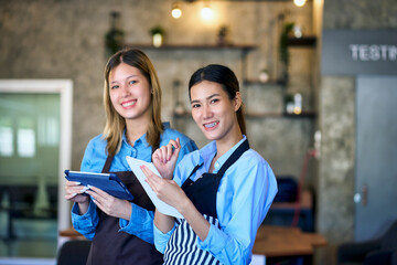 Two junior barista girls smile and lecture for learning in coffee cafe to be profressional of...