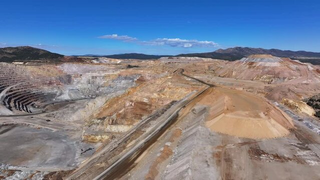 Aerial gold copper mine tailings pit Ely Nevada 4K pull fast. Boom town along historic Pony Express trail. Rural mining community. Ore transported to Japan for smelting. Precious minerals.