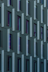 Perspective view to facade of modern corporate building with colorful reflections in windows