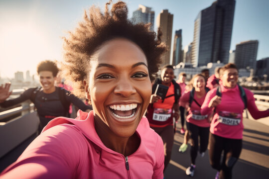 Black female marathon runner is taking a selfie picture while running , crowd of other runners and city view in the background