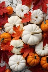 A lot of orange and white pumpkins and red maple leaves on marble white background. Holiday decoration, festive autumn decor. Concept of Thanksgiving day or Halloween. Flat lay autumn composition