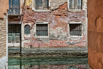 Old medieval worn out brick wall building in Venice, Italy.