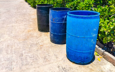 Blue trash garbage cans dirty street Playa del Carmen Mexico.