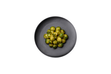Delicious boiled Brussels sprouts on a ceramic plate on a dark concrete background