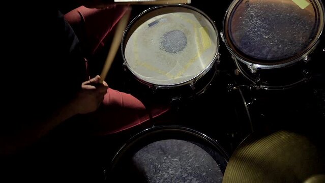 Top view of hands of rock musician drummer playing hitting drums and cymbals.