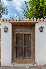 Beautiful old wooden door of a traditional mansion in the town of Spetses, in Spetses island,...