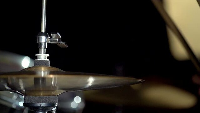 Hands of musician drummer holding drum sticks hitting on hi-hat cymbal