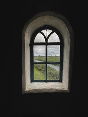 Vintage style window located inside a traditional Dutch windmill. Beautiful views looking out the window of the canals and windmills in Kinderdijk, Netherlands. A UNESCO World Heritage Site since 1997