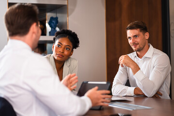 Male mature caucasian ceo businessman leader with diverse coworkers team executive managers group meeting. Multicultural professional businesspeople working together on research plan boardroom.