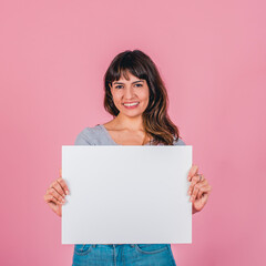 Smiling woman holding a blank sign against a pink background