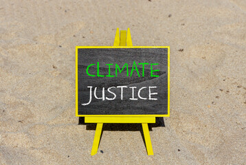 Climate justice symbol. Concept words Climate justice on beautiful black chalk blackboard. Chalkboard. Beautiful sand background. Business environment climate justice concept. Copy space.