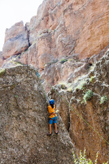 Fototapeta premium climber boy. a child in a helmet climbs a rock. sports on the street.