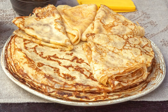 Fresh baked pancakes stacked in a plate for sale in a street cafe. Close-up