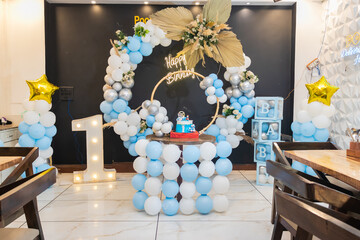 one year birthday decoration with white and blue balloons from different angle