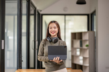 Female college student holding a tablet in her workspace