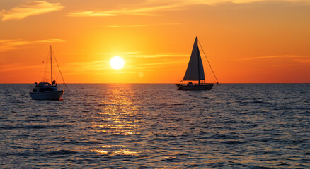 Fototapeta premium shadow of a sailboat on the sea with a beautiful sunset in high resolution