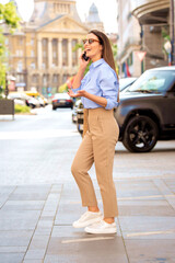 Full length of an attractive woman walking on the street and talking on the phone