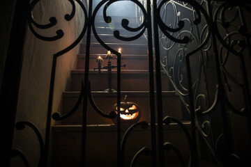 Inside of old creepy abandoned mansion. Silhouette of horror ghost standing on castle stairs to the basement. Spooky dungeon stone stairs in old castle with light. Horror Halloween concept