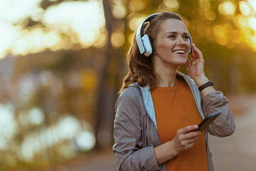 smiling elegant female in fitness clothes in park