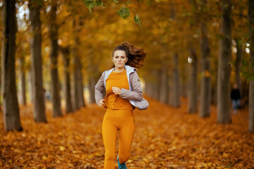 young woman in fitness clothes in park jogging