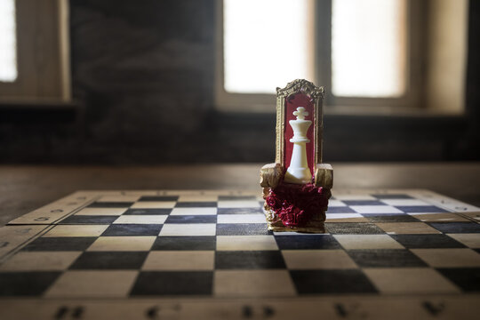 Red Royal Chair Miniature On Wooden Table. Medieval Throne On Chessboard. Chess Board Game Concept Of Business Ideas And Competition And Strategy Ideas Concept. Selective Focus