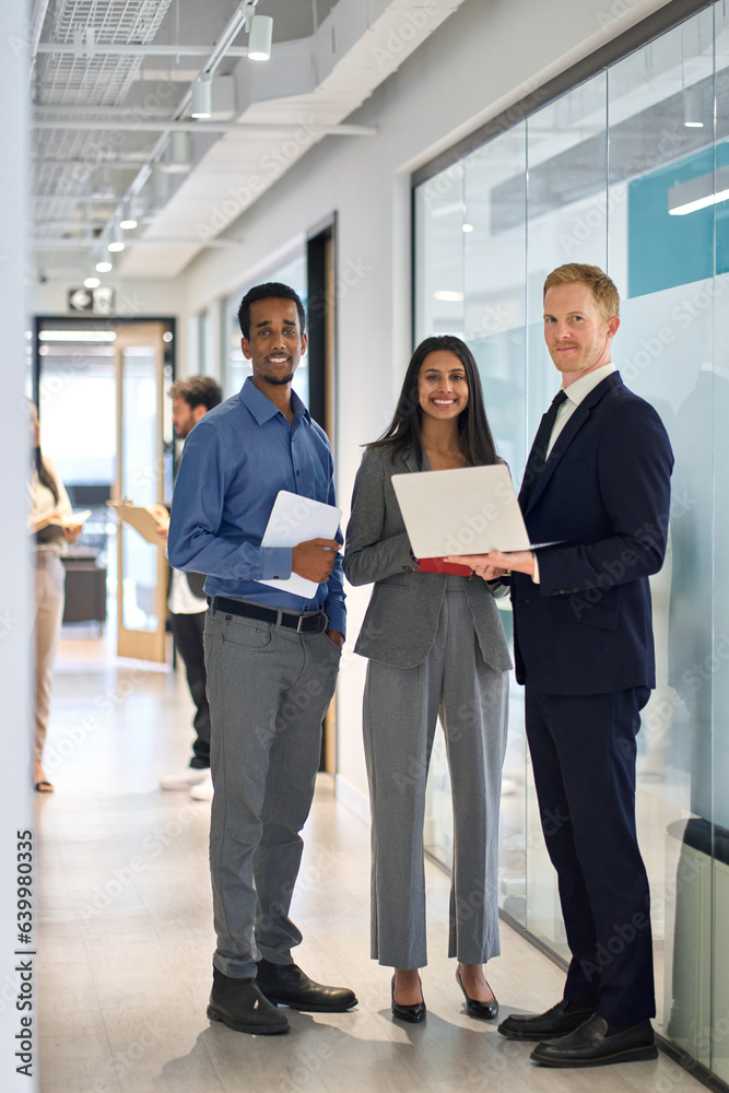 Wall mural three professional happy diverse international team young business people workers standing in corpor