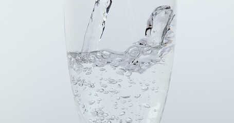 Water being poured into Glass against White Background