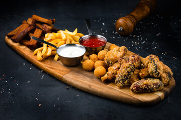 Snacks breaded mozzarella cheese balls, rye bread croutons, French fries, fried meat and sauces.