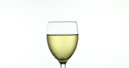 White Wine being poured into Glass, against White Background