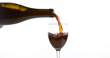 Red Wine being poured into Glass, against White Background